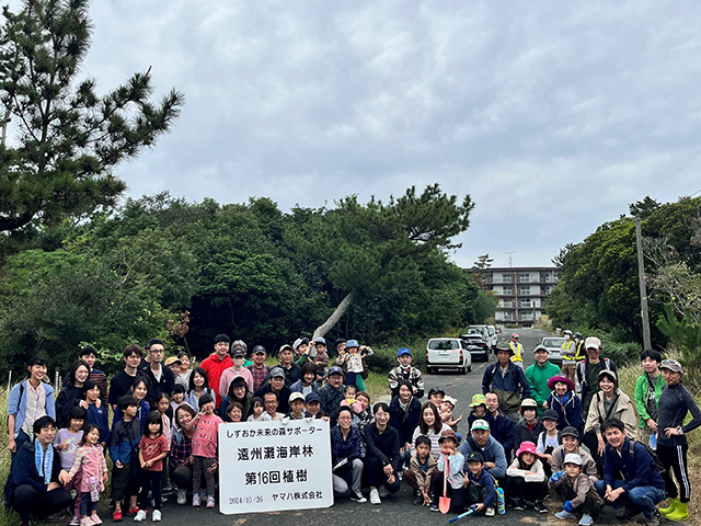 Group photo taken during a tree-planting activity organized by Yamaha Corporation.