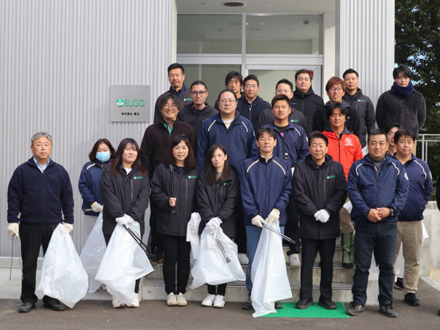 Group photo taken during roadside cleanup activities around SUGO Co., Ltd.