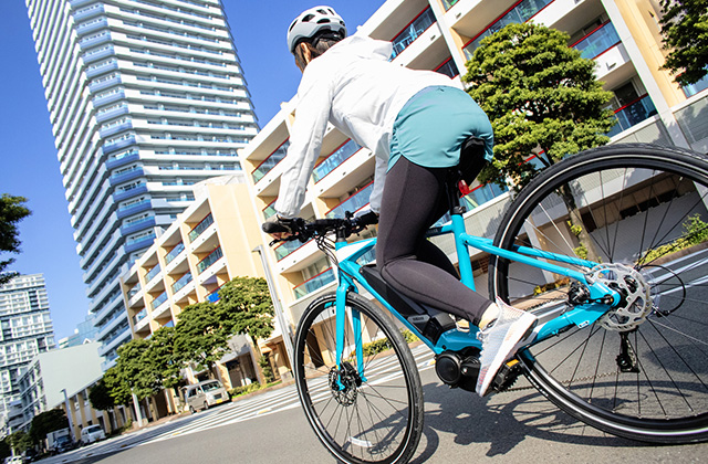 女性が電動自転車に乗ってサイクリングをしている様子