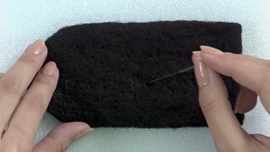 型紙A-1よりも一回り大きくちぎった黒いシート羊毛を形を整えながらニードルで刺していく