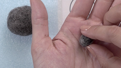 手のひらで軽く丸めたグレーの羊毛で型紙を参考にマズル部分を作る