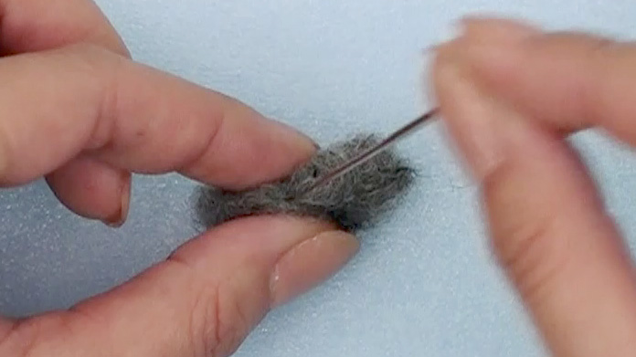 手のひらで軽く転がしたグレーの羊毛を刺し固め 幅1cm 長さ2.5cmの棒を作る