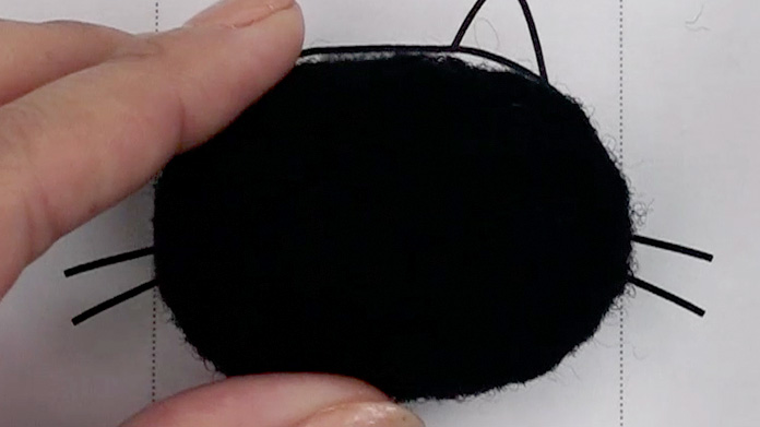 型紙に合わせて　シート羊毛の黒で楕円形を作る