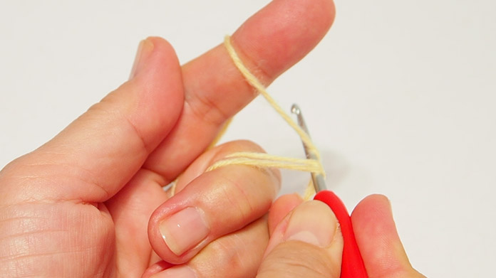 Insert the hook at the top of the fingers and loop under the 3 threads.