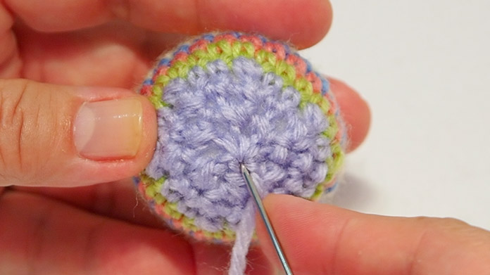 Insert the needle into the closed hole to hide the wool.