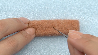 Colour the small end. Lightly poke the mixed felt over the whole shape.