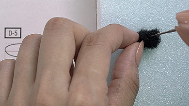 Tear off a piece of black sheet felt one size bigger than pattern D-5 and form the shape while poking with a needle.