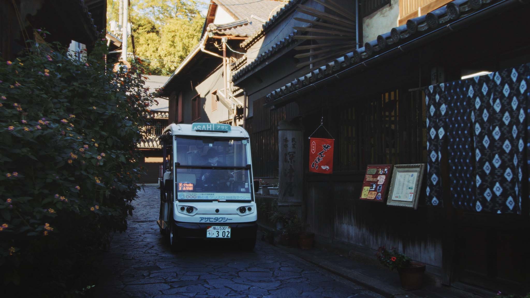 One of the low-speed electric taxis at work in a town full of narrow and hilly streets(Field-Born Vol. 1)